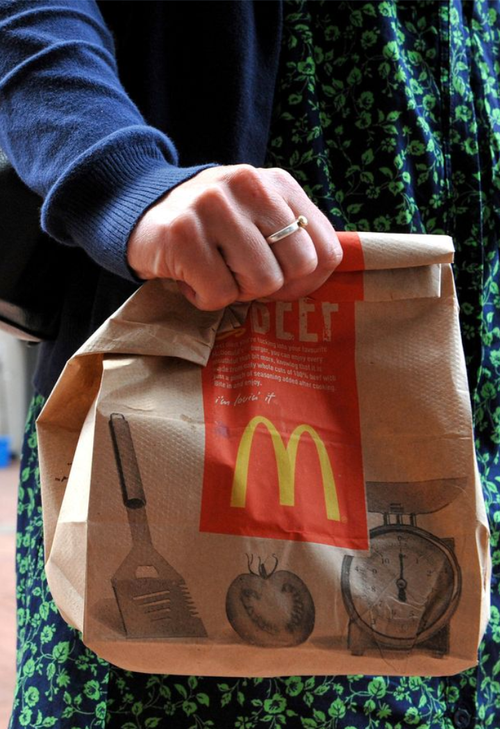 En hånd holder en McDonalds-pose