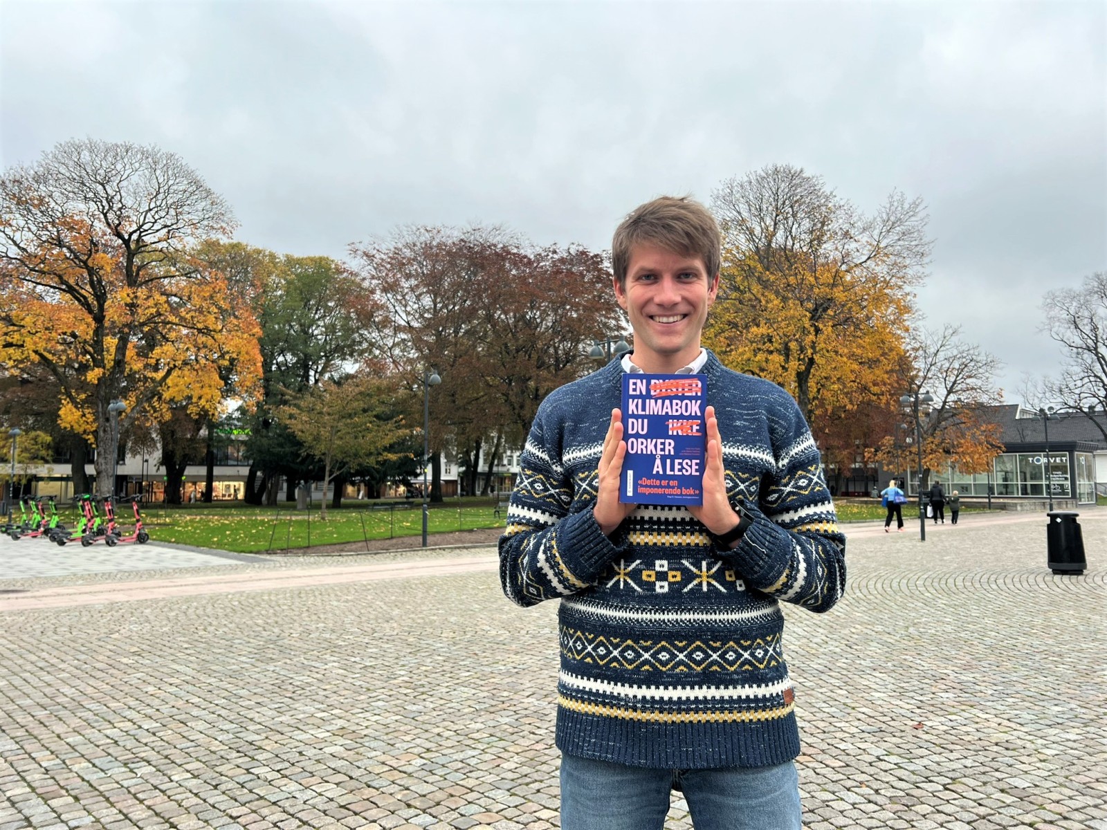 Hauk Are Fjeld på Torvet i Kristiansand med boken sin.